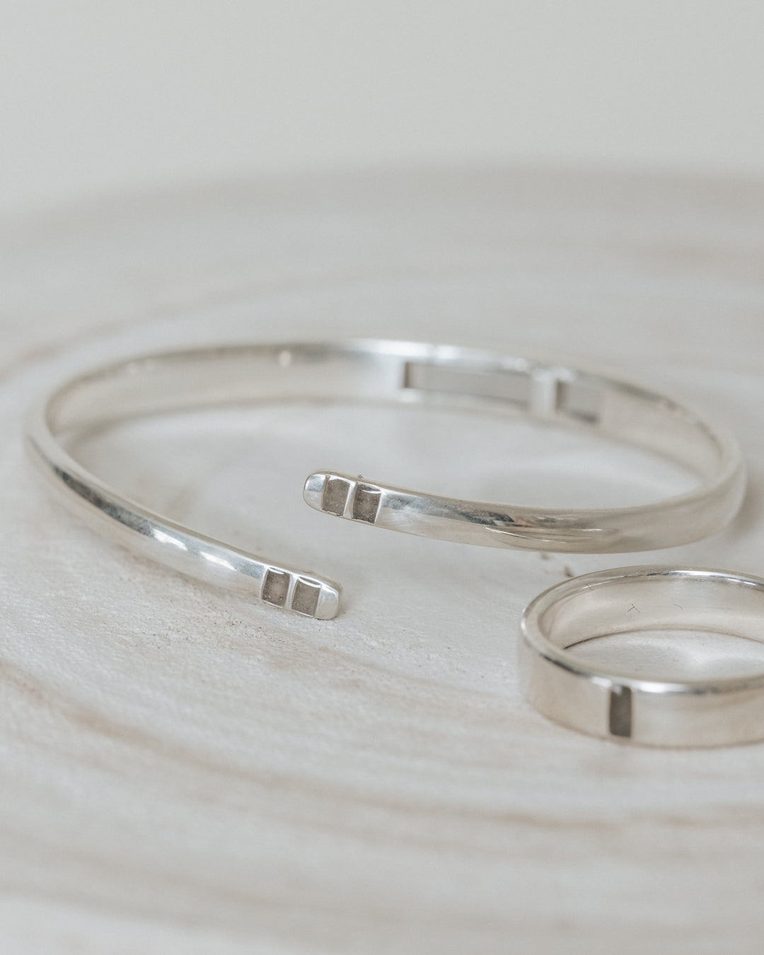 A close up showing the cremation settings in two of close by me jewelry's memorial ring and bracelet designs