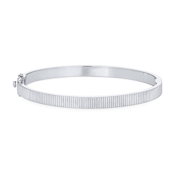 Close By Me's Tessa Bangle Cremation Bracelet in 14K White Gold lays flat and in a closed position with the cremation setting on the side facing away from the camera against a solid white backdrop.
