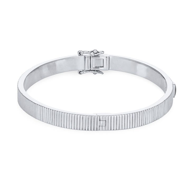 Close By Me's Tessa Bangle Cremation Bracelet in 14K White Gold lays flat and turned to the right in a closed position against a solid white backdrop.