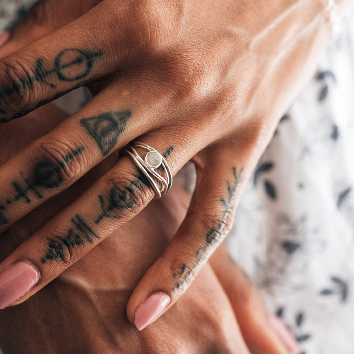 a close up showing a model wearing the sterling silver three band memento ring with ashes