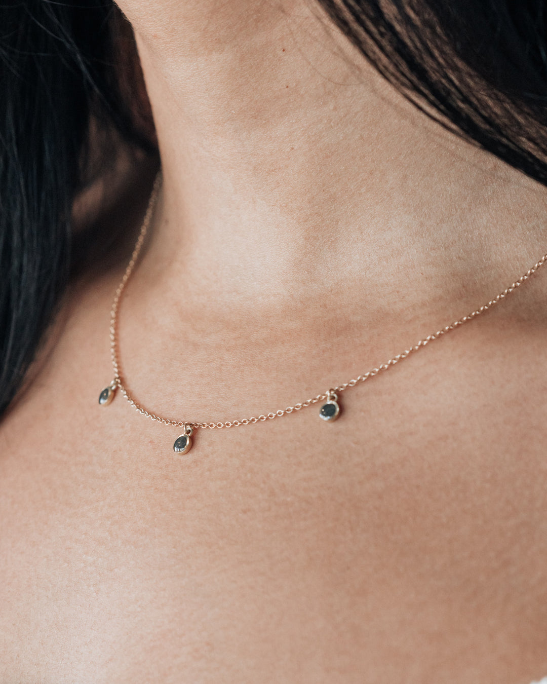 a slightly angled photo of a model close up featuring the drop memorial necklace