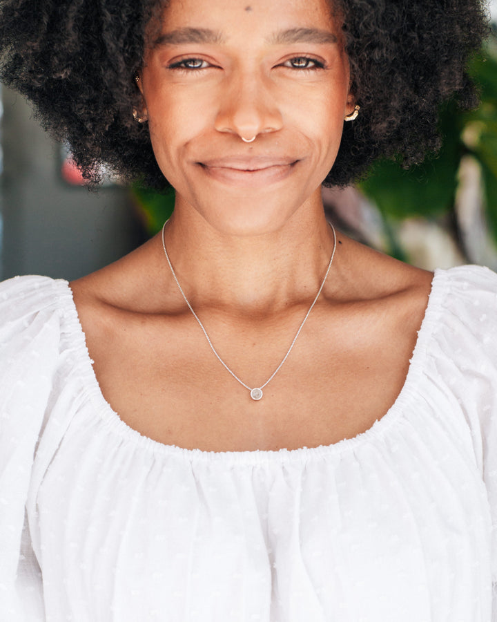 This photo shows a model wearing the Sterling Silver 6mm Sliding Solitaire Necklace with Cremains designed and set with ashes by close by me jewelry