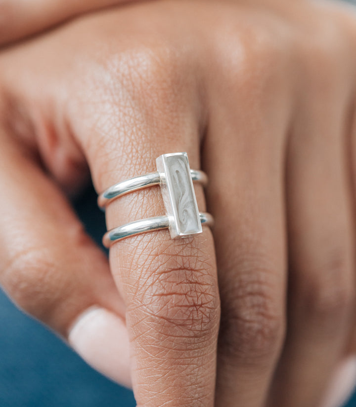 This photo shows a model wearing close by me jewelry's Sterling Silver Bar Ashes Ring on her index finger