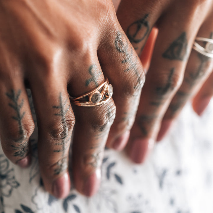 This photo shows a close up of a model wearing close by me jewelry's 14K Rose Gold Double Setting Ring on her middle finger