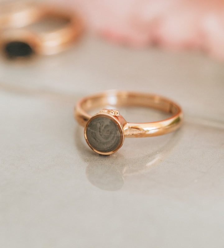 This photo shows the 14K Rose Gold Fleur de Lis Ring design with cremated remains by close by me jewelry lying flat