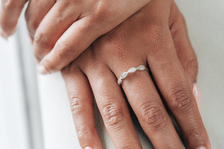 This photo shows the Sterling Silver Four Setting Ashes Ring by close by me jewelry on a model's middle finger