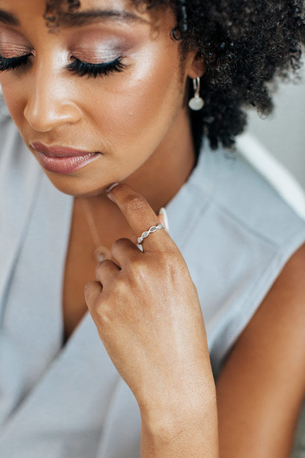 This photo shows a model wearing the Sterling Silver Four Setting Ashes Ring by close by me jewelry on her index finger