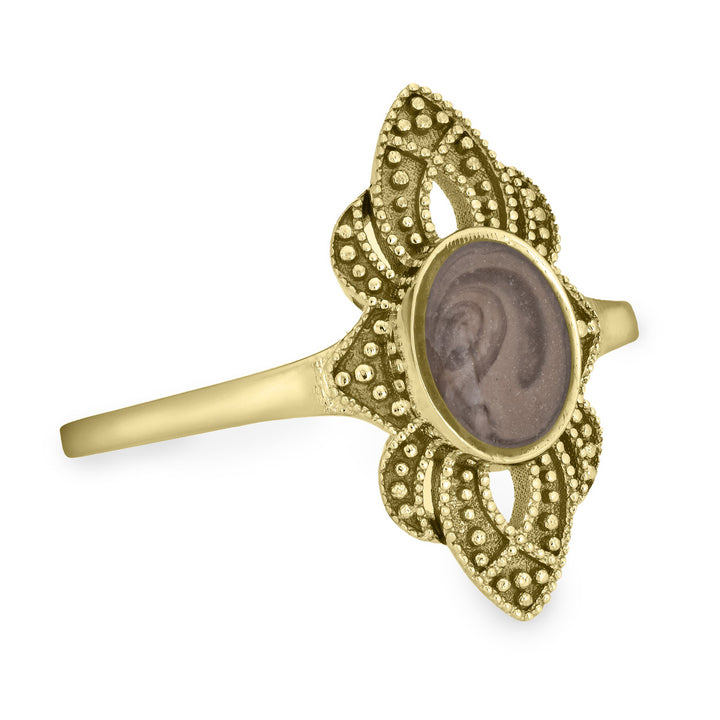 Pictured here is a close-up side view of Close By Me Jewelry's vintage-style World War II Cremation Ring in 14K Yellow Gold set against a solid white background. This version of the ring has a larger oval bezel containing solidified cremated remains. The ashes setting in this photo is medium gray in color and features a distinct swirl pattern.