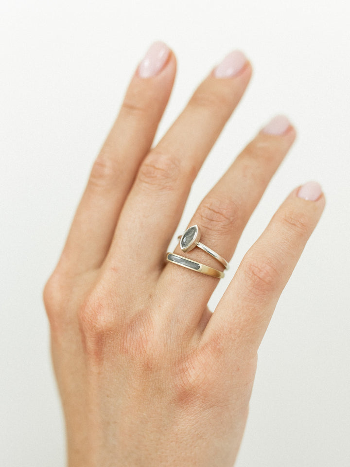 This photo shows the Sterling Silver Marquee Stacking and 14K Yellow Gold Smooth Band Ring designs by close by me jewelry stacked on a model's hand