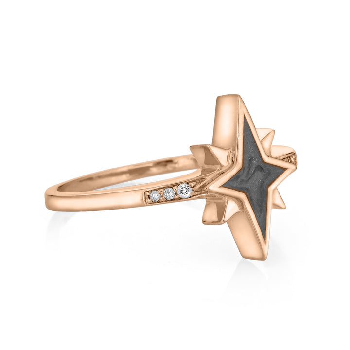 Pictured here is close by me jewelry's North Star Champagne Diamond Band Cremation Ring in 14K Rose Gold from the side to show its medium gray ashes setting and three round diamonds set into its band.