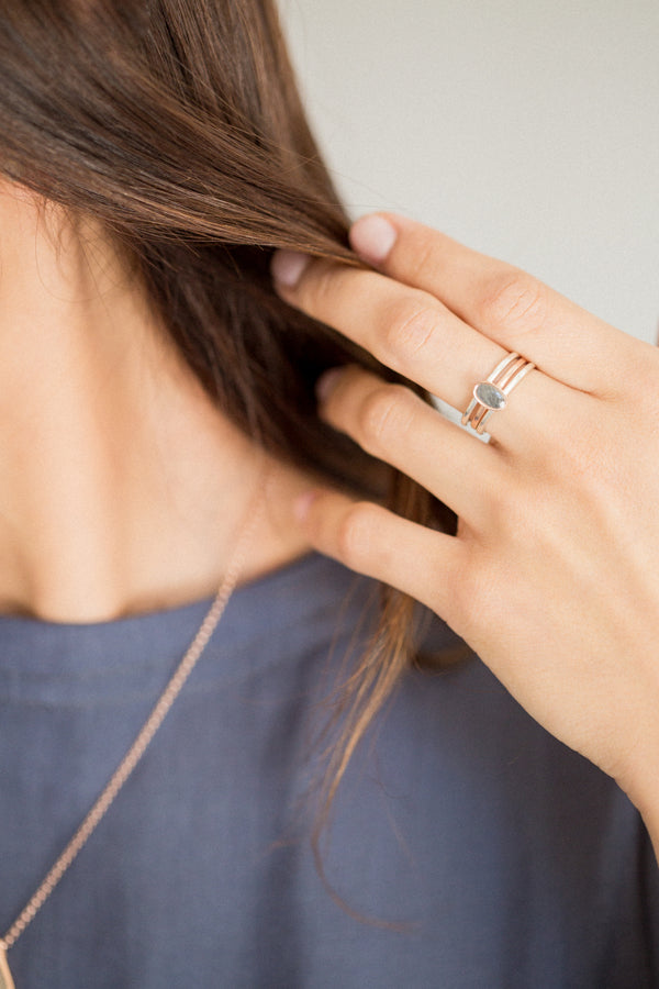This photo shows a model wearing a Stacking Ashes Ring set in mixed metals by close by me jewelry; The Oval Stacking Ring is shown in 14K Rose Gold