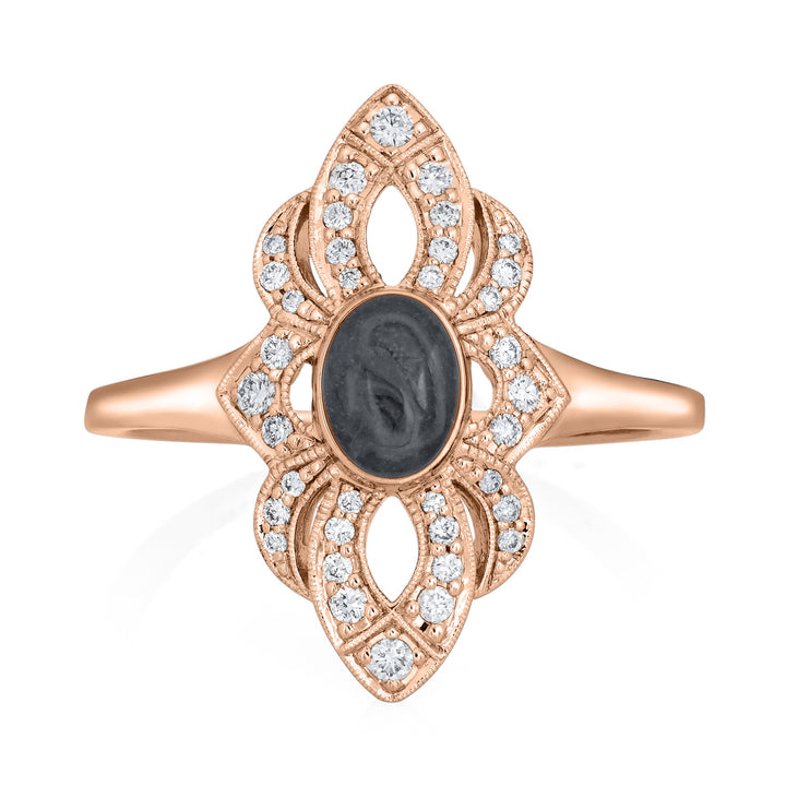 Close-up, front view of Close By Me Jewelry's vintage-style World War II Cremation Ring in 14K Rose Gold with Champagne Diamonds, set against a solid white background. The oval bezel in the center contains solidified cremated remains that are a dark gray in color with a subtle swirled pattern.