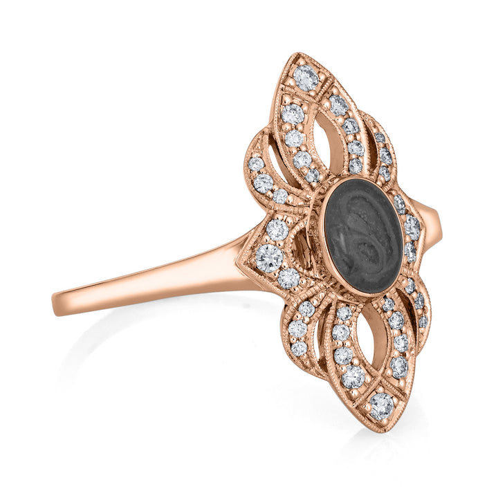 Close-up, side view of Close By Me Jewelry's vintage-style World War II Cremation Ring in 14K Rose Gold with Champagne Diamonds, set against a solid white background. The oval bezel in the center contains solidified cremated remains that are a dark gray in color with a subtle swirled pattern.