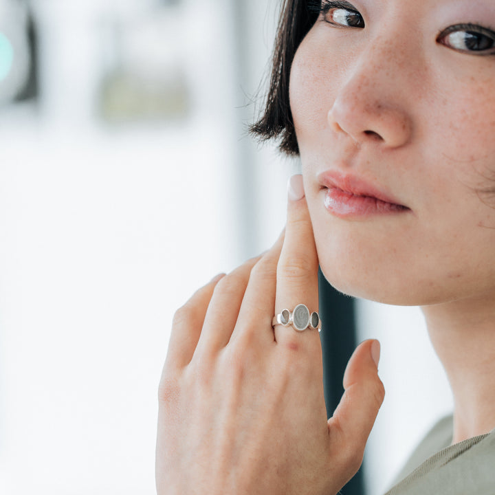 Pictured here is a model wearing close by me jewelry's Triple Oval Cremation Ring in Sterling Silver on her index finger