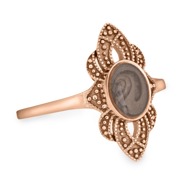 Pictured here is a close-up side view of Close By Me Jewelry's vintage-style WWII Cremation Ring in 14K Rose Gold, featuring a large oval bezel containing solidified ashes.