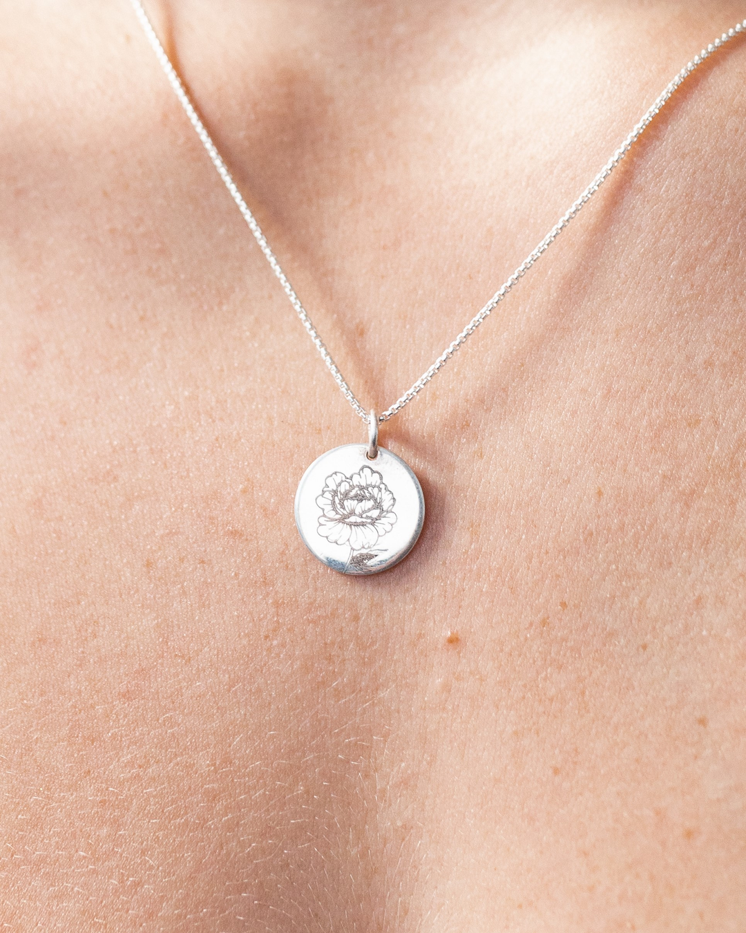 Close-up, front view of Close By Me's Circle Necklace with Birth Flower (Peony) Engraving in Sterling Silver, set against a solid white background.