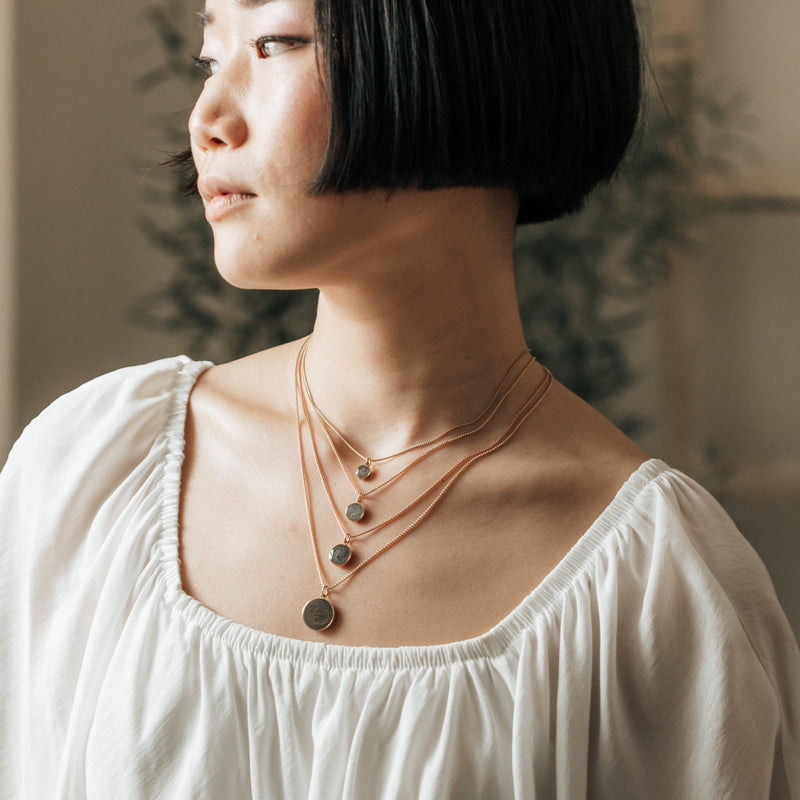 A model gazes to the side, wearing Close By Me&
