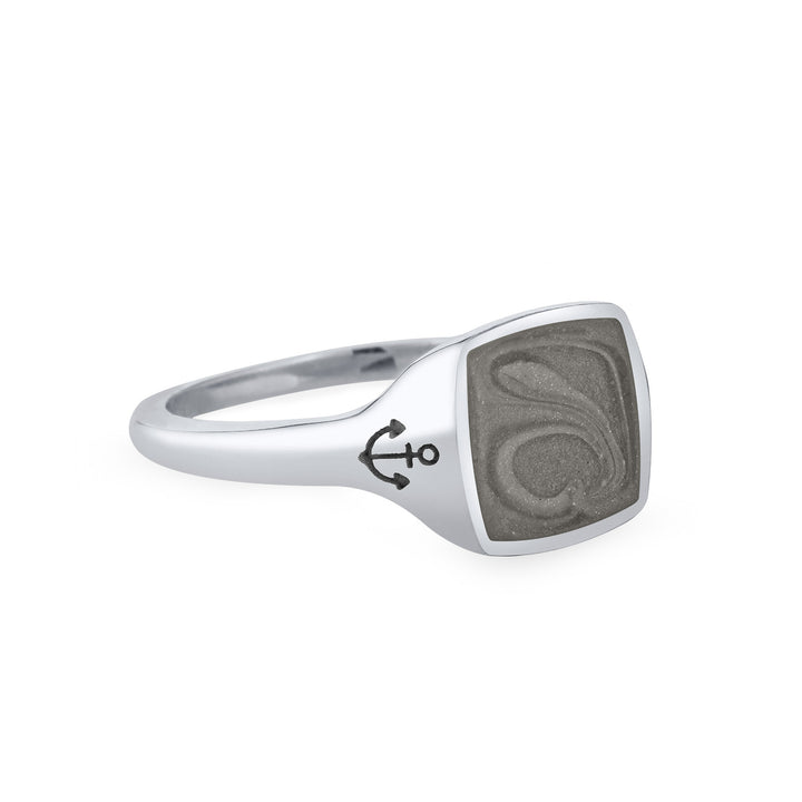 Close By Me's Anchor Signet Cremation Ring in 14K White Gold floats in the center of a solid white background, facing right. The square-shaped cremation setting is dark grey in color and has a bold, visible swirl. The anchor imprint in the band, on the left side of the setting, is clearly visible.