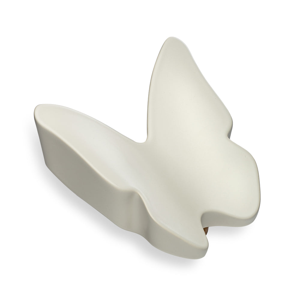 Side view of a white butterfly-shaped ceramic urn on a white background