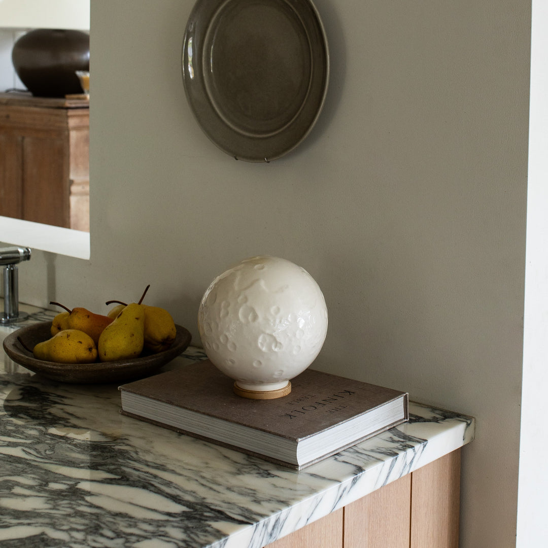 Ceramic moon cremation urn on a book styled