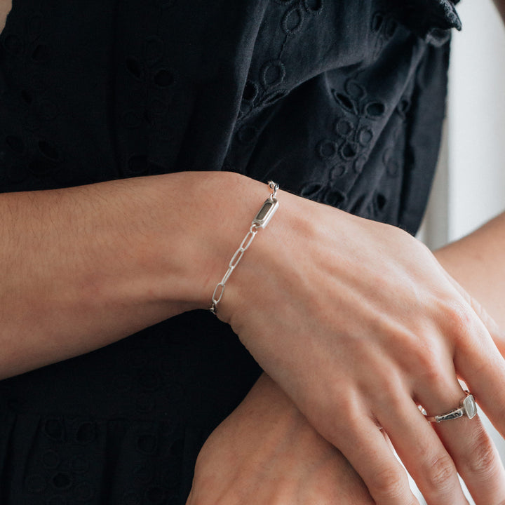 A close-up view of Close By Me's Chain Link Cremation Bracelet in Sterling Silver on the wrist of a female model.