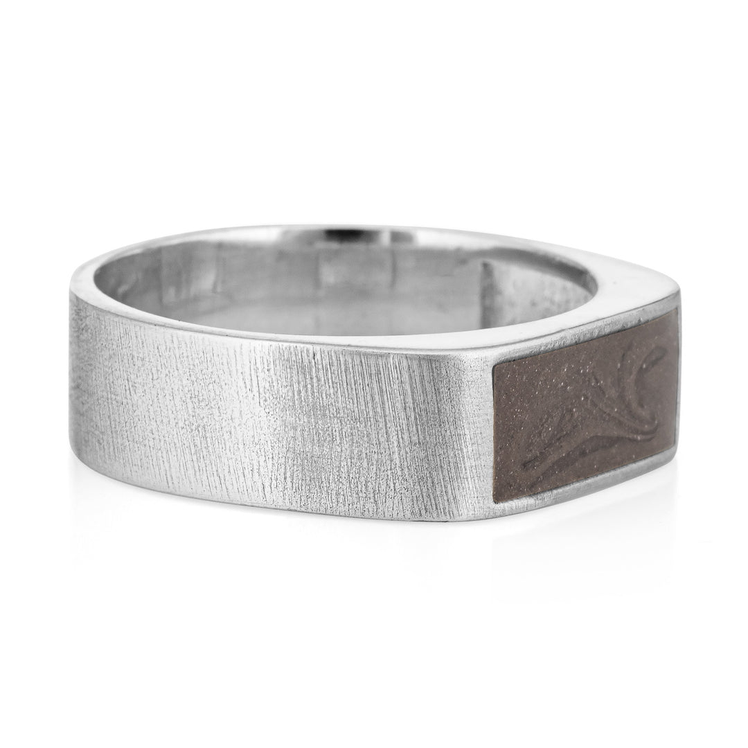 Pictured here is close by me jewelry's Men's Classic Band Cremation Ring design in Sterling Silver from the side to show its dark grey ashes setting and thickness of its brushed band