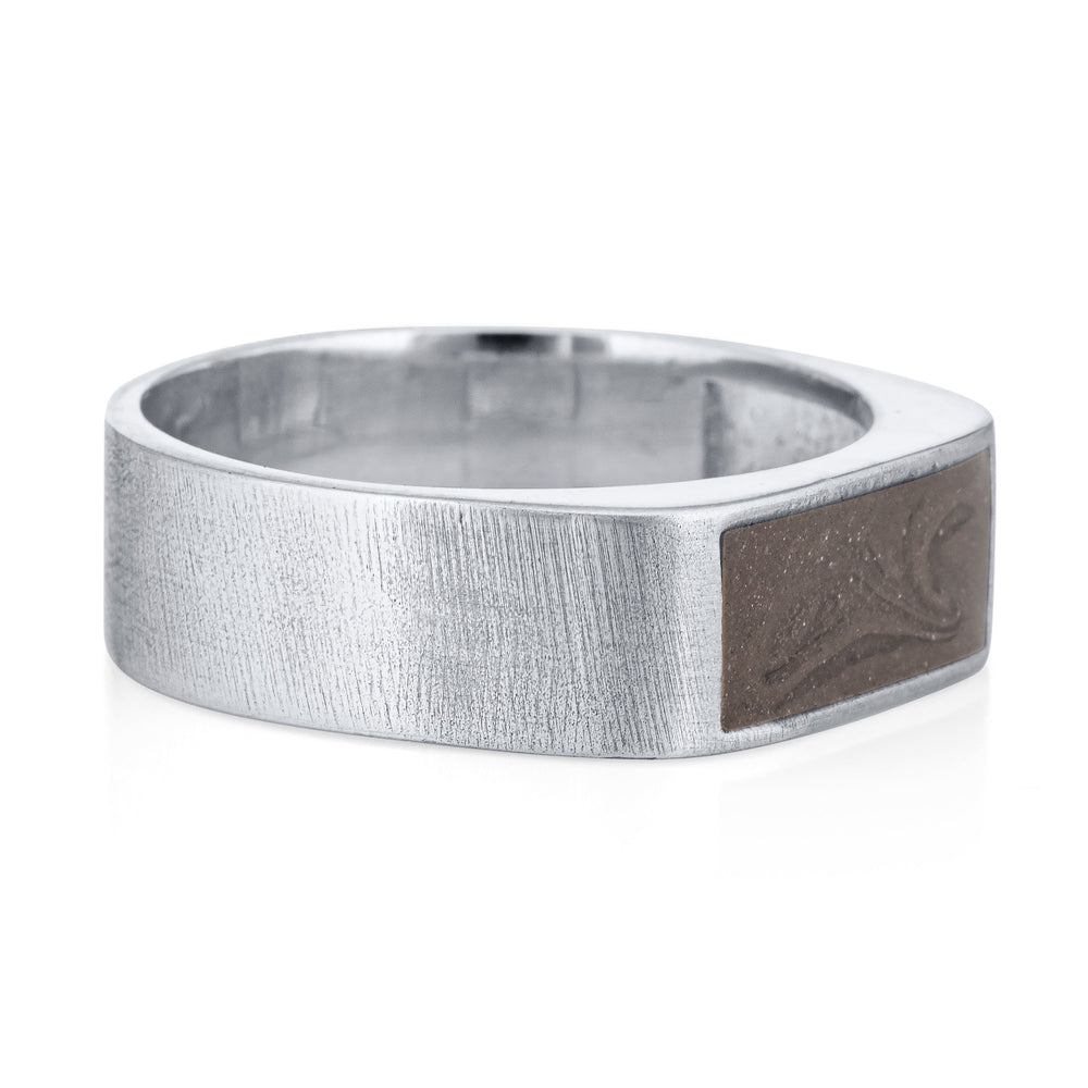 Pictured here is close by me jewelry's Men's Classic Band Cremation Ring design in 14K White Gold from the side to show its dark grey ashes setting and thickness of its band.