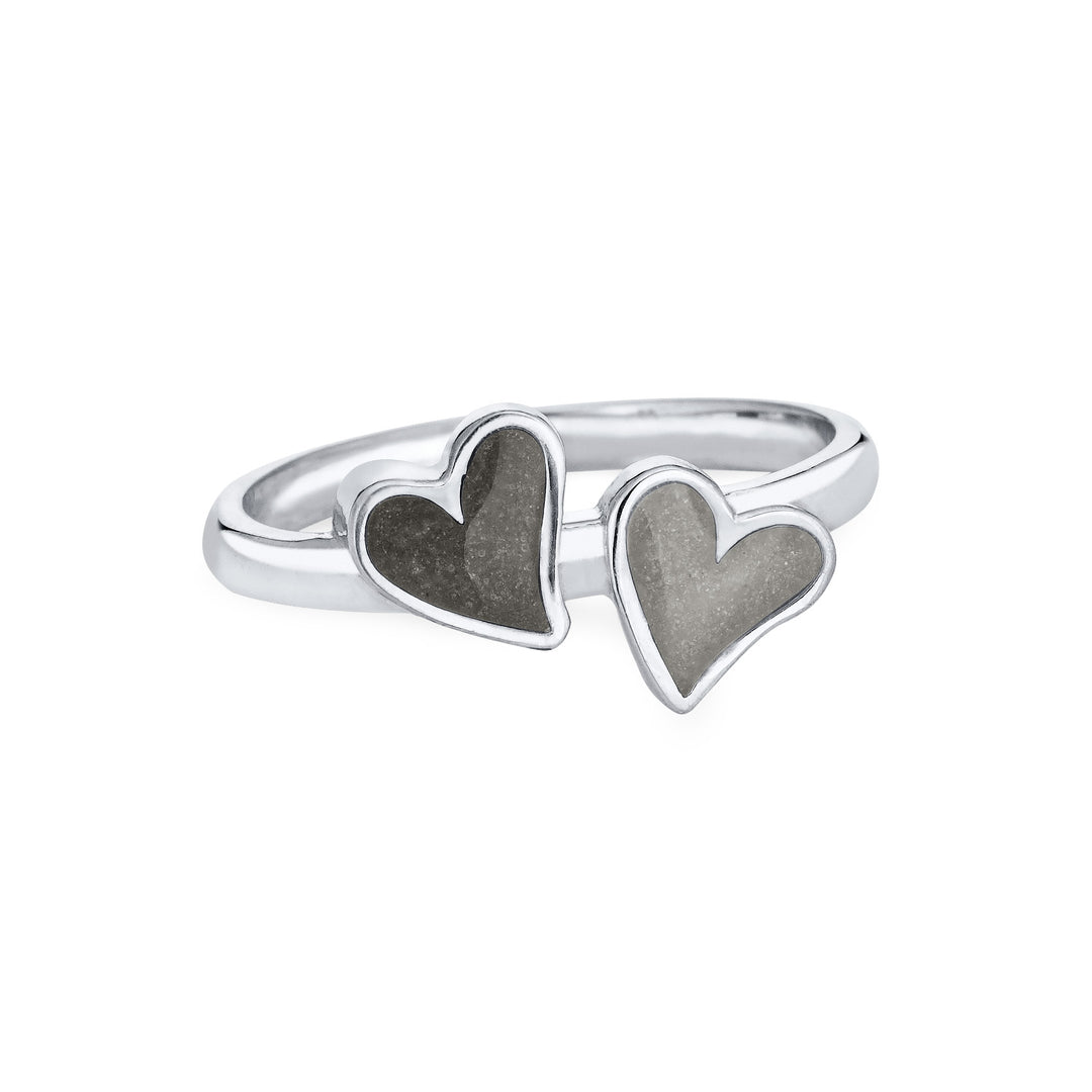 Front view of Close By Me's 14K White Gold Double Heart Cremation Ring, floating against a white backdrop. The left heart has a darker ashes setting, and the right heart has a light grey ashes setting.