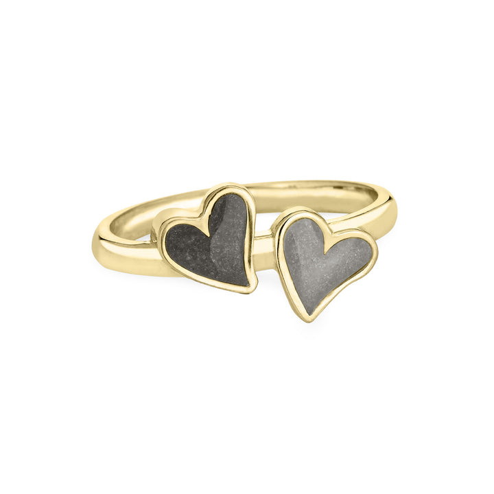 Front view of Close By Me's 14K Yellow Gold Double Heart Cremation Ring, floating against a white backdrop. The left heart has a darker ashes setting, and the right heart has a light grey ashes setting.