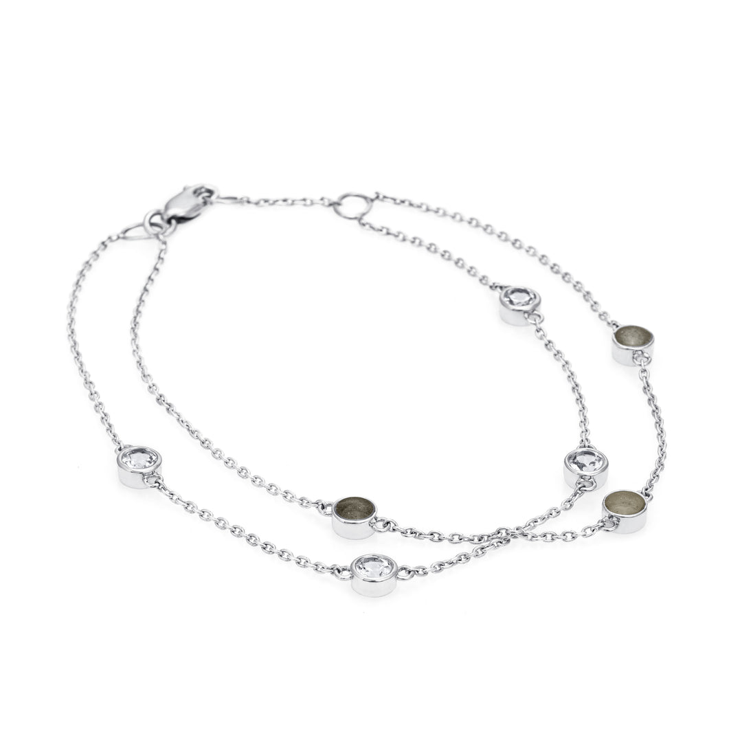 Close By Me's Double Strand Cremation Bracelet in 14K White Gold laid flat in a circular, closed position with the strand of four white topazes crossing the strand of three ash-filled charms.