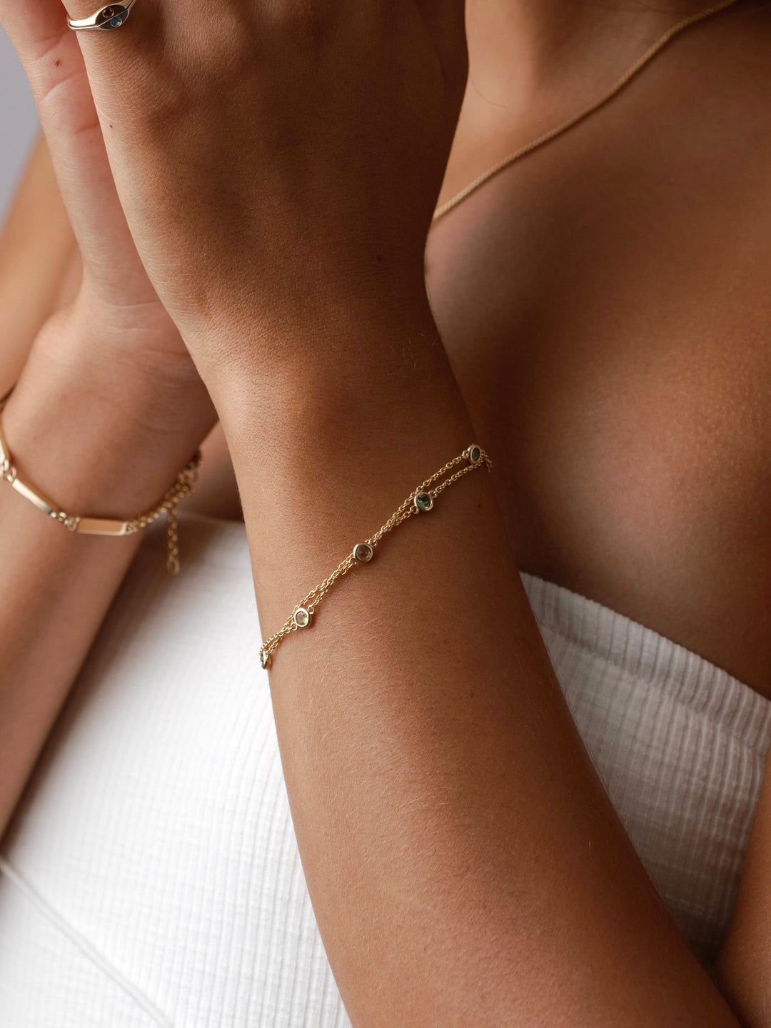 Close By Me's Double Strand Birthstone Bracelet in 14k yellow gold on a model's wrist.