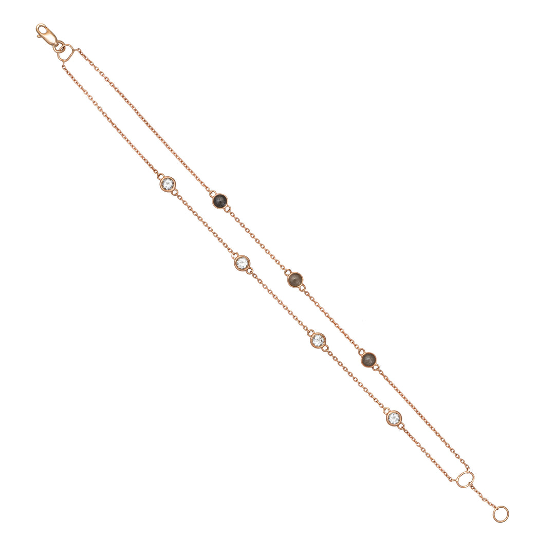 Close By Me's Double Strand Cremation Bracelet in 14K Rose Gold laid flat in a vertical, opened position stretching diagonally across a solid white background with the strand of four white topazes parallel to the strand of three ash-filled charms.