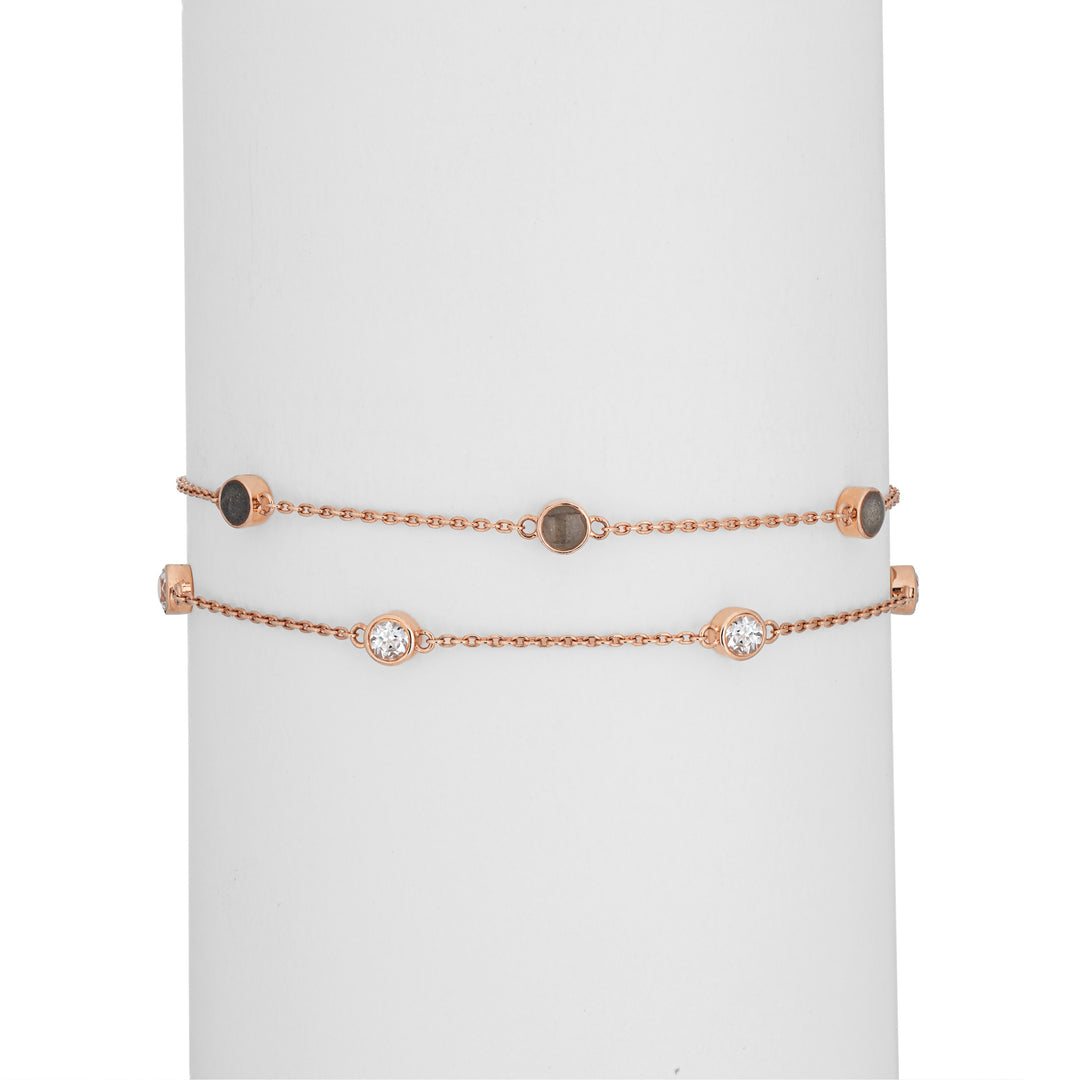 Close By Me's Double Strand Cremation Bracelet in 14K Rose Gold on a cylindrical white holder with the strand of three ash-filled charms parallel atop the strand of four white topazes.