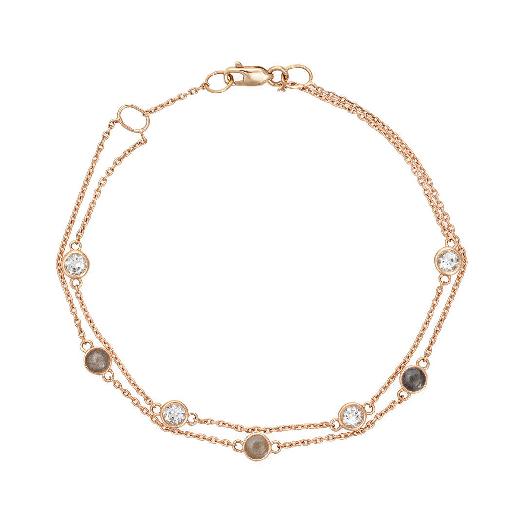 Close By Me's Double Strand Cremation Bracelet in 14K Rose Gold laid flat in a circular, closed position with the strand of four white topazes resting parallel atop the strand of three ash-filled charms.