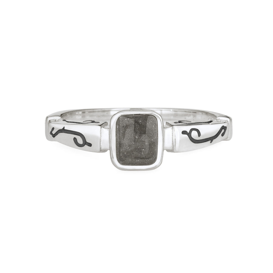 Close By Me's Emerald Square Setting Cremation Ring in Sterling Silver is floating in the center of a solid white background. The dark grey cremation setting is facing the camera and the oxidized designs along the outside and top edge of the band are clearly visible.