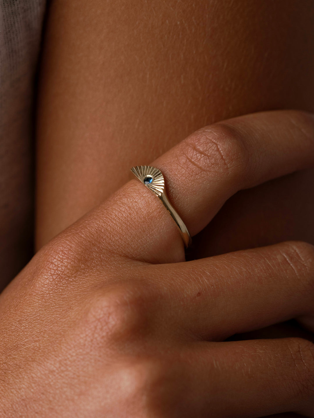 The Radiance Birthstone Ring by Close By Me in 14k yellow gold on a model's finger.