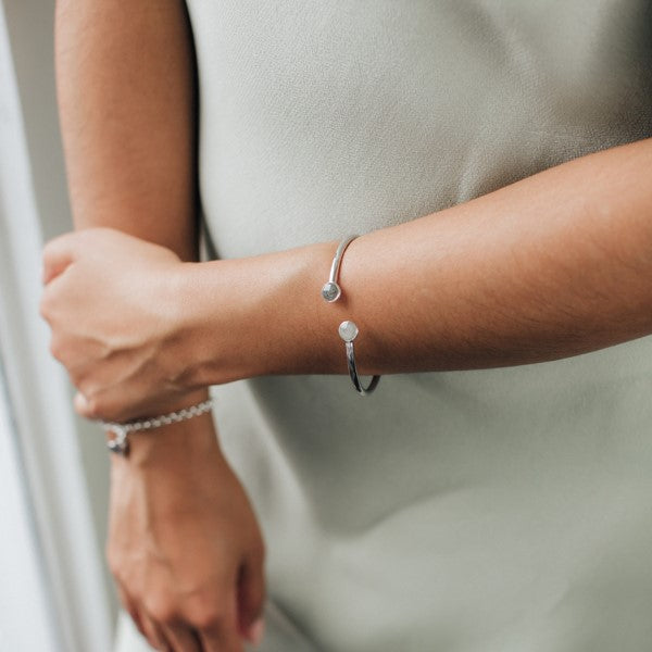 Close By Me's Flex Tube Cuff Cremation Bracelet on the arm of a female model.