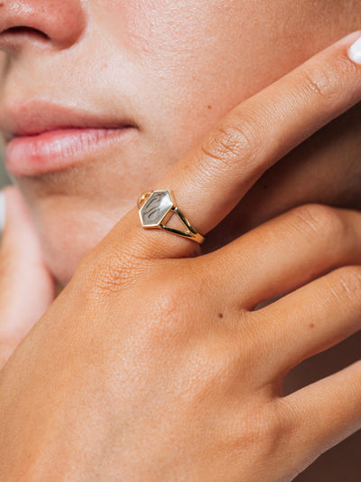 Close-up, cropped photo of Close By Me's Hexagon Split Shank Cremation Ring on the index finger of an olive skinned woman.