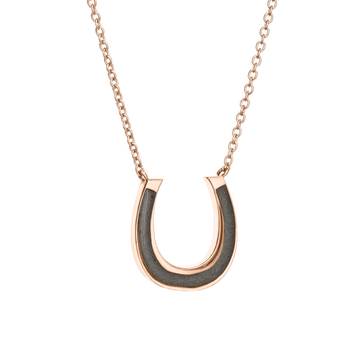 Close-up side view of Close By Me Jewelry's 14K Rose Gold Horseshoe Cremation Necklace set against a white background.