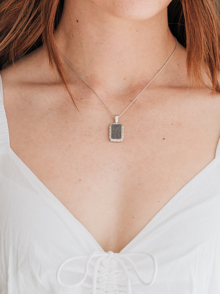 A close up showing a model in a white dress wearing the large cable cremains necklace design in sterling silver with ashes by close by me jewelry