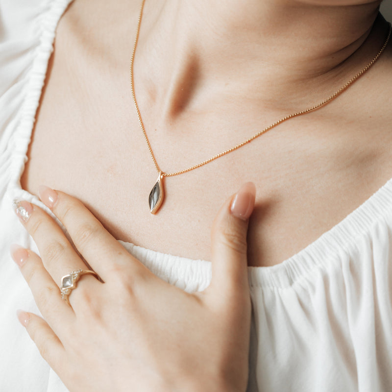 The Leaf Ashes Necklace design by close by me in 14K Rose Gold around a model in a white top&