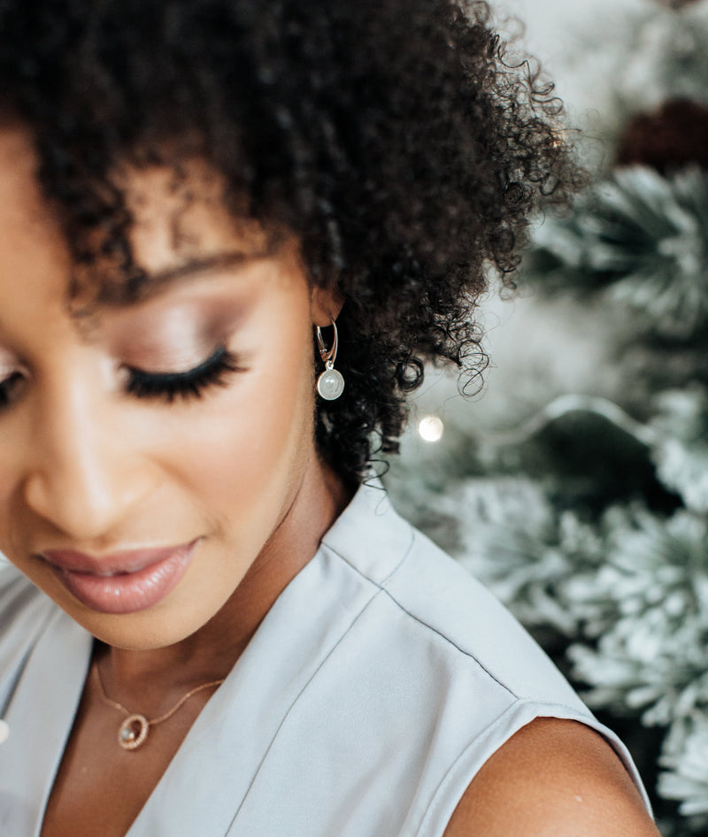 a photo showing a holiday gift themed photoshoot with a model wearing sterling silver grief earrings as a memorial on Christmas by close by me