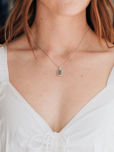 A close up showing close by me jewelry's Sterling Silver Medium Cable Cremains Pendant around a model's neck