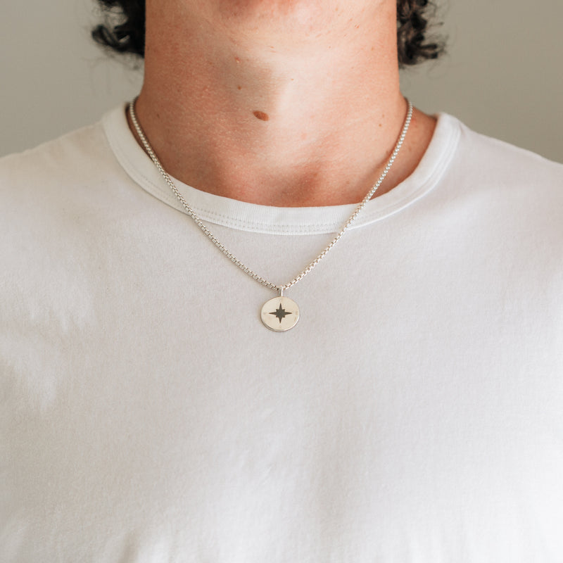 A close-up of a young man wearing Close By Me Jewelry&