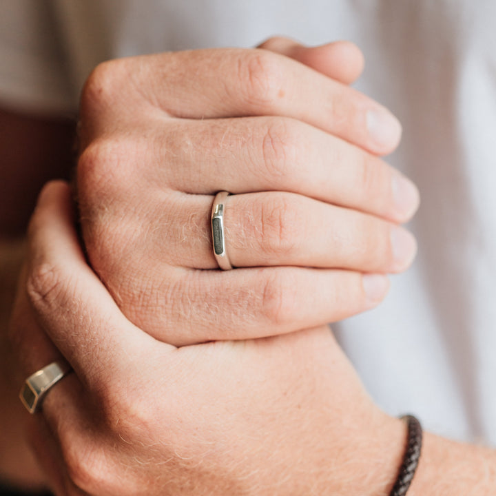 A close up showing two sterling silver men's memorial ring designs on a male model's hands