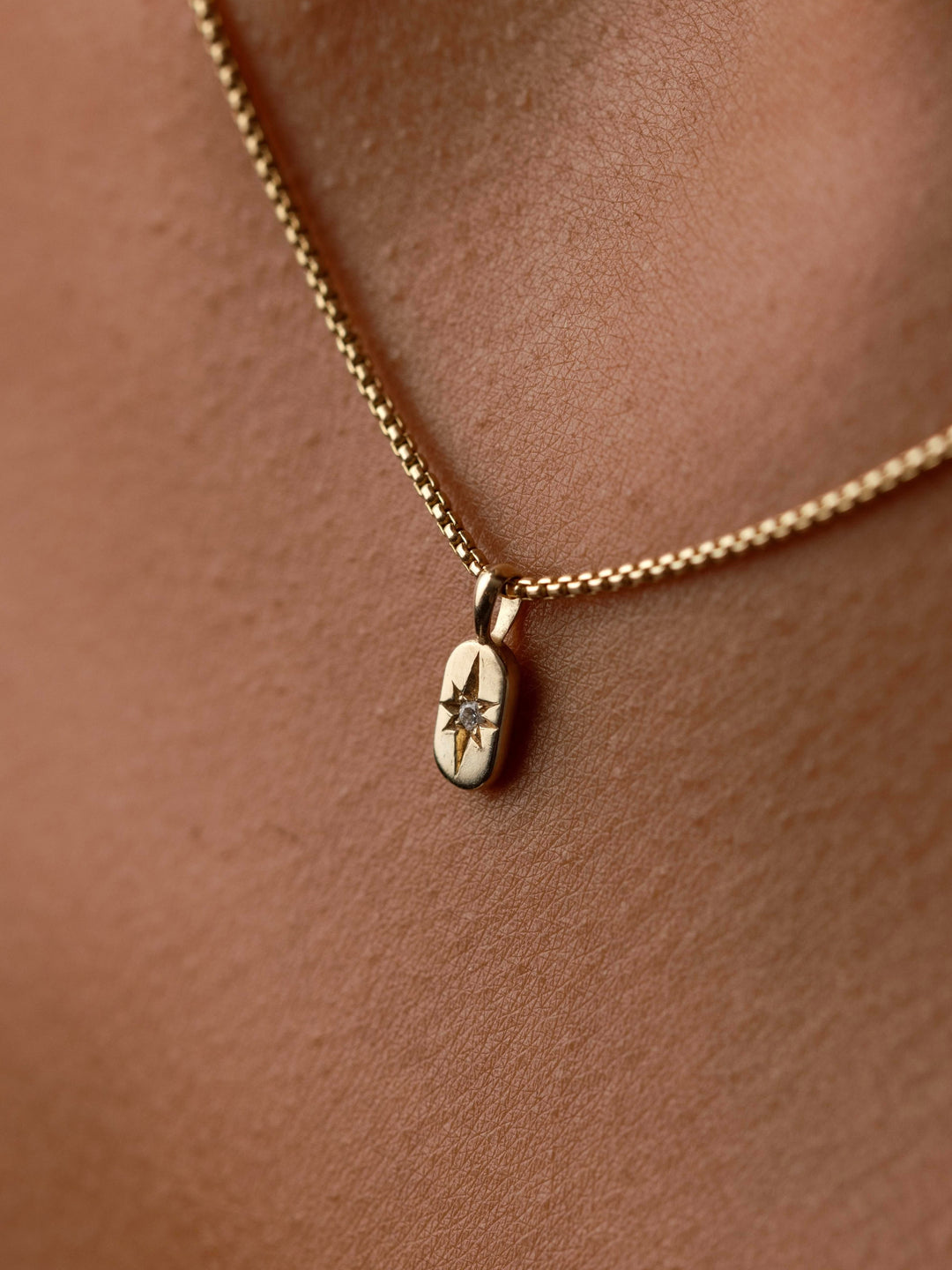 Close-up of The Guidance Birthstone Charm from Close By Me in 14k yellow gold being worn.