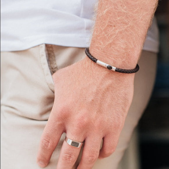 this newly designed leather cord cremation bracelet is shown on the wrist of a male model close up