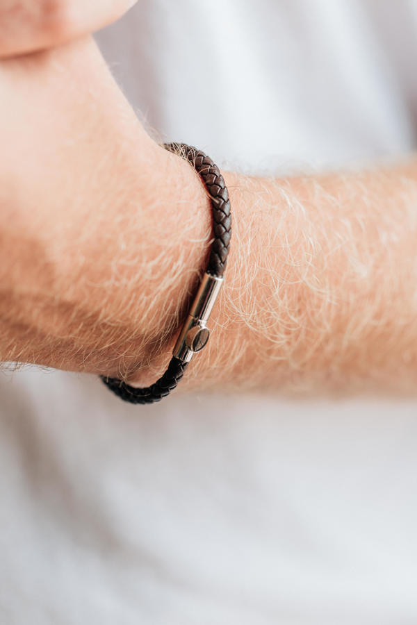 a very close up photo of the new design of the leather cord bracelet on a male wrist
