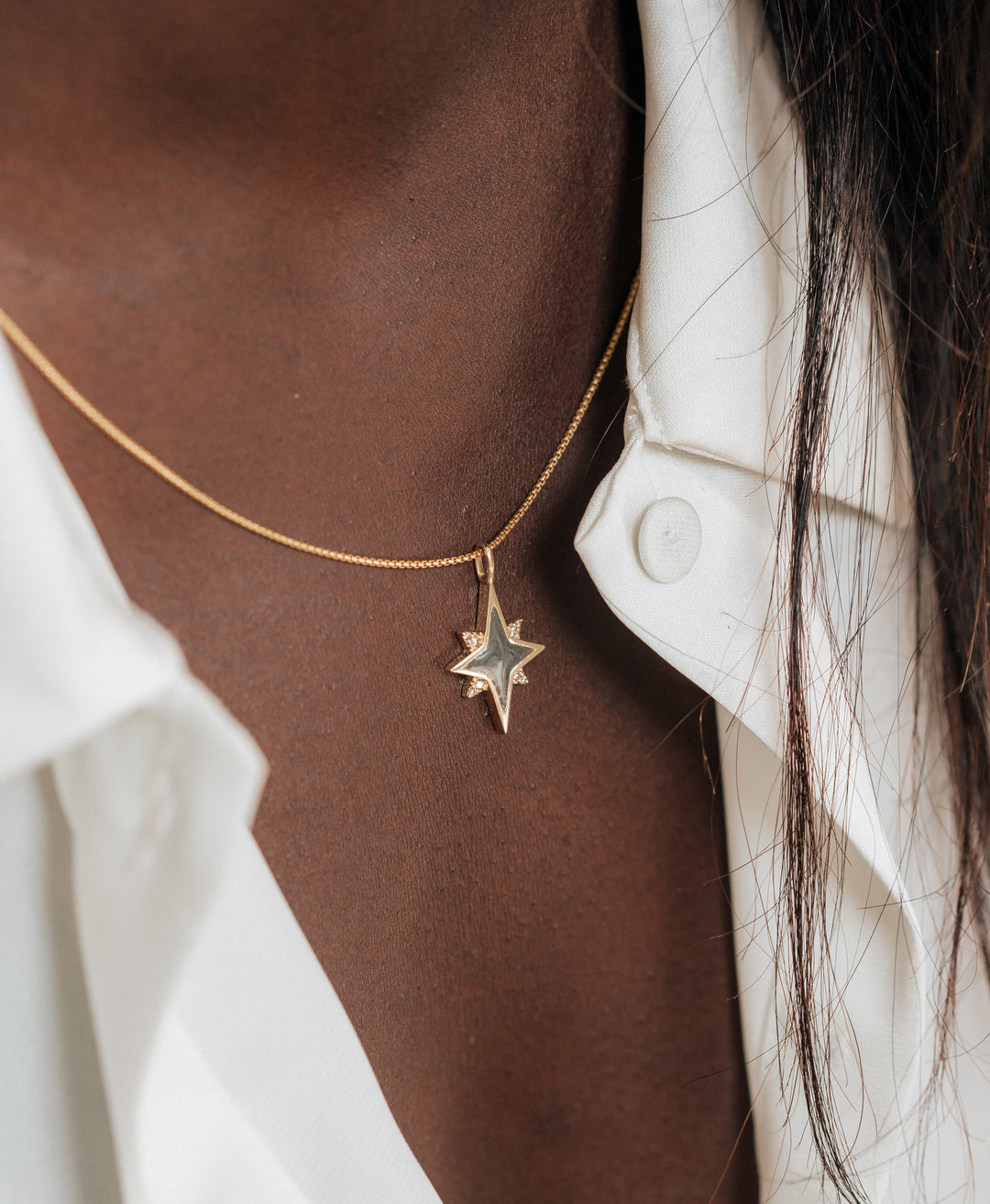 A close up showing the 14K Yellow Gold and Champagne Diamond North Star Pendant with ashes designed by close by me jewelry around a model's neck