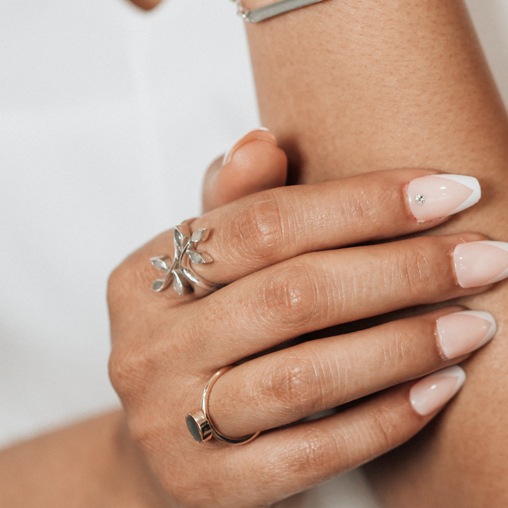 Pictured here is the Sterling Silver Olive Branch Ashes Ring design by close by me jewelry on a model's right index finger